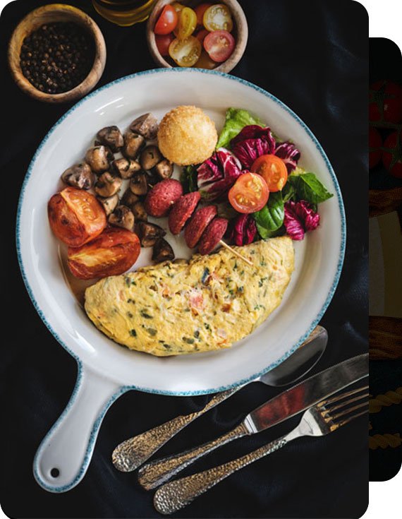 Platillo de omelette de huevo con papa cambray, jitomate deshidratado, tomate cherry, lechuga, sobre un plato estilo sartén, a un lado de cubiertos listos para disfrutar una comida saludable.