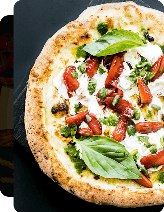 Pizza fresca estilo gourmet dulce-salada con queso burrata, fresas, hojas de albahaca y aceite de oliva sobre una tabla de madera negra con fondo negro, clave para tener variedad semanal en tu cocina. 